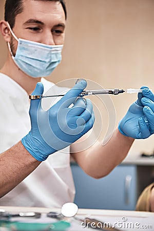 Lifeâ€™s got problems, weâ€™ve got solutions. The dentist is going to make a painkiller injection to his patient. Stock Photo